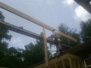 Carpenter setting a ridge beam over a new addition frame — Ice Dam Removal by Roofing Brothers in Westernville