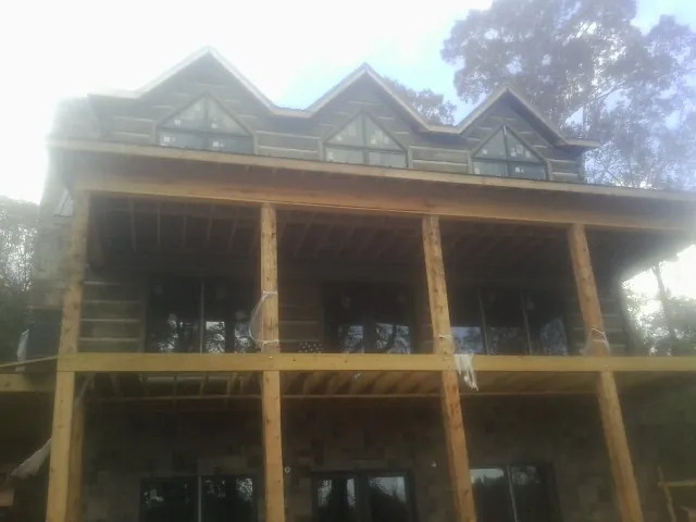 Dormers and porch framing on a large log home under construction — Roof Coating work by our crew in Westernville