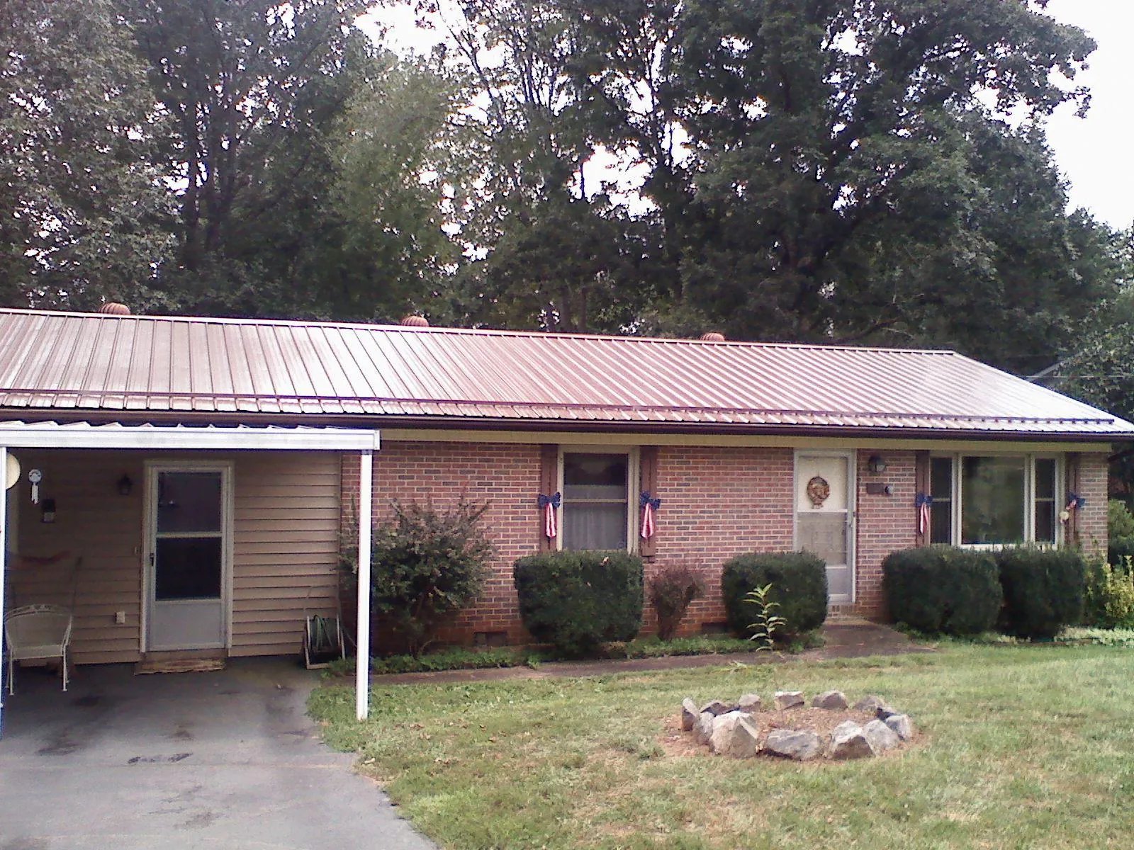 Bronze metal roof and carport on a brick ranch home — Roof Repair work by our crew in Westernville